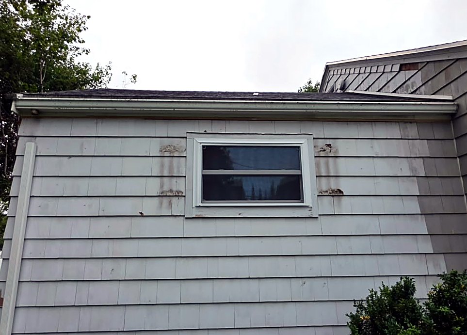 Before: damaged clapboard siding on a Worcester, MA cape ahead of rot repair